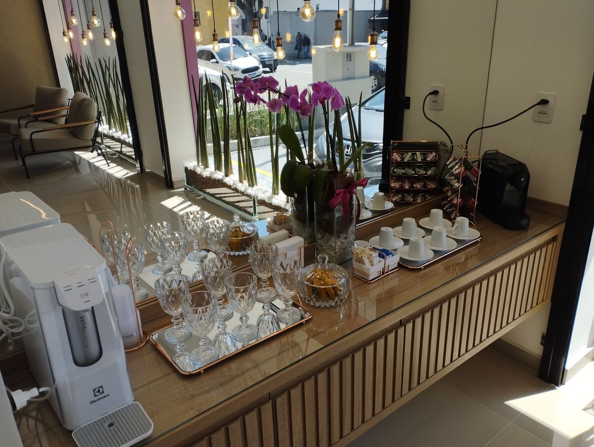 Coffee bar com taças de cristal, orquídeas e máquina de café